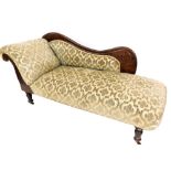 A Victorian mahogany chaise lounge, with a foliate carved shaped back and scroll end, upholstered in