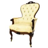 A Victorian mahogany lady's spoon back armchair, with foliate carved crest rail, overstuffed chequer