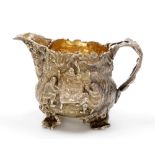 A George III silver repousse jug, of ogee form, with an oak leaf and blossom shaped handle, decorate