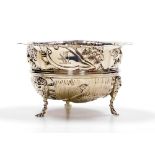 An Edward VII silver bowl, with a shaped edge, the body embossed with dogs, a swan, flowers, leaves
