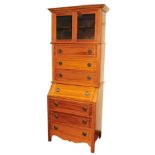 An early 20thC hardwood bureau bookcase, the top with out swept pediment, above two glazed doors and