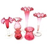 A group of Victorian and later cranberry glass, comprising three trumpet shaped vases and three furt