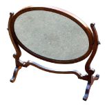 An Edwardian mahogany swing frame toilet mirror, with an oval mirror raised on a shaped frame, 55.5c