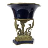 An Empire style urn, the domed blue glazed top with brass supports on a tripod base, 42cm high, 36cm