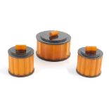 A set of three Art Deco Bakelite trinket boxes, each of circular form on black with orange highlight