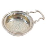 A George V silver tea strainer, with scroll handle and pierced bowl, London 1912, 1¾oz.