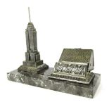 A 1960's/1970's New York novelty cigarette dispenser, on a granite base, with applied Empire State b