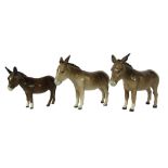 Three Beswick Donkeys, two John Beswick examples with black back stamp, 13cm high, and a foal, 11cm