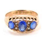 A 9ct gold gypsy ring, set with three oval dark blue stone, and seed pearls with pierced design bord