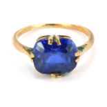 A single stone set dress ring, set with dark blue rectangular cut stone in double claw setting, yell