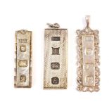 Three silver ingot pendants, one with scroll detailed border, the other brushed effect and another p