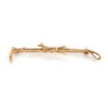 A 9ct gold horse whip brooch, with applied fox on horse whip bar, 6cm wide, 4.1g, boxed.