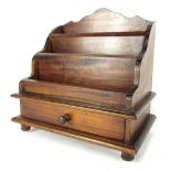 An early 20thC mahogany letter rack, the two section top with single drawer, on bun feet, 34cm high,