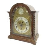 An early 20thC oak cased mantel clock, with brass and silvered coloured dial, with a Roman numeric c
