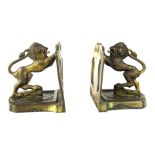 A pair of late 19thC brass bookends, each depicting heraldic lion pushing a shield, on a shield shap