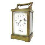 A French brass carriage timepiece, the rectangular white enamel face with black Roman numerals secon