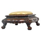 A stained and carved oriental footstool, with shaped top overstuffed in later Regency striped silk m