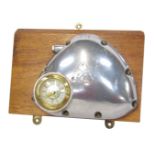 A novelty wall clock, formed from a cap or cover from an engine, with inlaid brass dials, on an oak