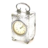 A miniature Edwardian hammered silver carriage type clock, the white dial bearing Roman numerals, th