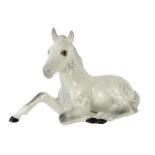 A Beswick seated foal, with grey dappled detailing, No 915, 12cm wide.