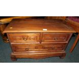 A low chest of two over one drawer, with carved drawer fronts.