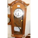 A Hermle oak cased chiming wall clock.