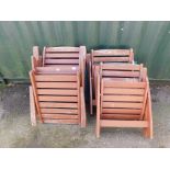 A set of four stained pine garden chairs with green cushions.