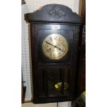 An oak cased wall clock, the carved and moulded top, above a gold finish numeric dial, with pendulum