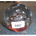 A domed glass paperweight, with red fire base and bubble design interior, 10cm high.