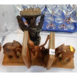 A group of carved wooden items, comprising a pair of elephant book ends, a kneeling fisherman figure