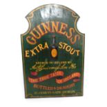 A Guinness Extra Stout wooden pub advertising sign, of shield form with raised relief Guinness bottl