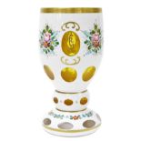 A Continental amber flashed glass goblet, overlaid in white glass, painted with sprays of flowers, o