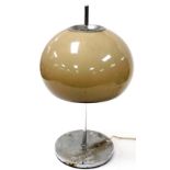A vintage 1970's table lamp, with a mushroom coloured glass shade, on a white metal stem and circula