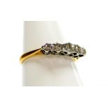 An 18ct gold and platinum five stone diamond dress ring, with illusion set tiny diamonds, in a raise
