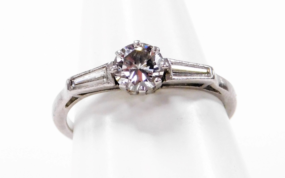 An Art Deco design diamond dress ring, the central round brilliant cut diamond in claw setting measu