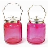 A pair of early 20thC cranberry glass biscuit barrels, with plated lids and handles, 27cm high inclu