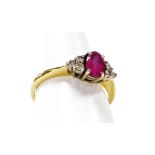 An 18ct gold ruby and diamond dress ring, the oval ruby in four claw setting, with three round brill