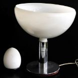 A futuristic table lamp, with an inverted opalescent glass shade, raised on a white metal stem and c