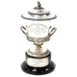 A George III silver campana shaped two handled trophy and cover, embossed with a band of vines, the