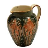 A Moorcroft Macintyre and Co Florian ware pottery jug, decorated with orange flowers and leaves agai
