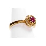 A 9ct gold ruby and diamond cluster ring, with central raised ruby approx 0.4cts, surrounded by twel
