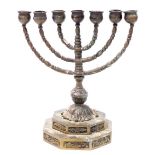 An early 20thC bronze menorah, on a stepped octagonal base decorated with panels of flowers, 23cm hi