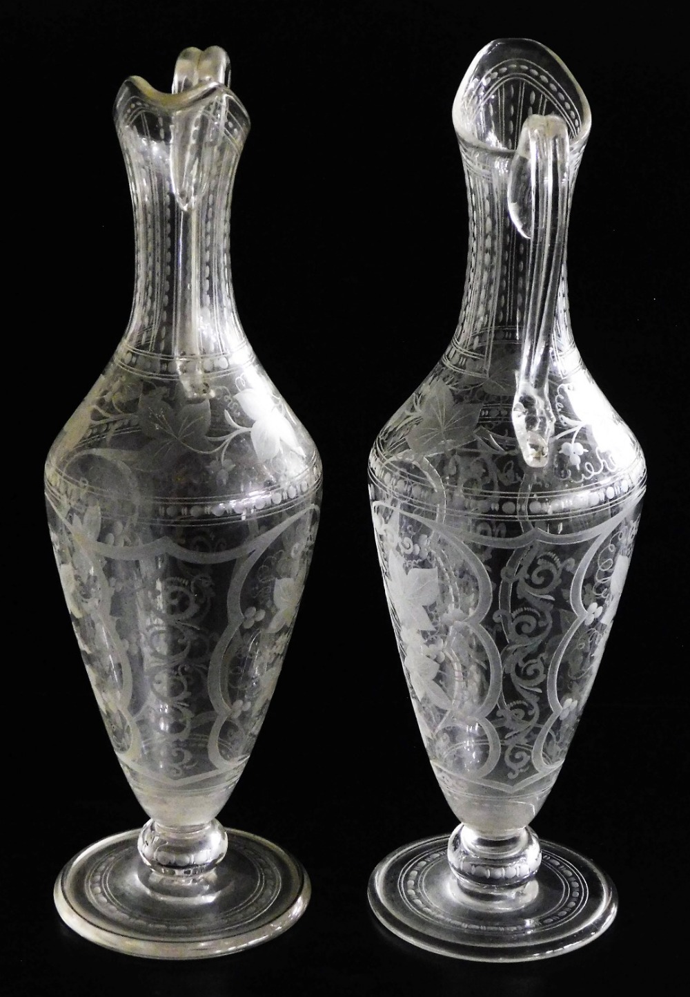 A pair of Victorian cut glass claret jugs, possibly James Powell, engraved with scrolling leaves and - Image 2 of 2