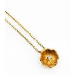 An 18ct gold diamond set floral pendant and chain, the flower pendant in brushed gold with central t