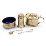 A George V silver three piece condiment set, comprising mustard pot and spoon, salt cellar and spoon