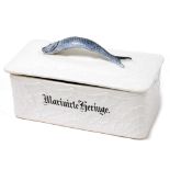 An early 20thC German pottery marinated herring box and cover, the lid with fish handle, titled to b