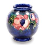 A Moorcroft pottery vase decorated in the Anemone pattern, against a cobalt blue ground of globular