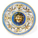 A 19thC Cantagalli maiolica dish, with a raised central panel depicting Bacchus, surrounded by a bor