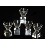 Five Art Deco Masonic firing glasses, with tapering faceted bowls, raised on square bases.