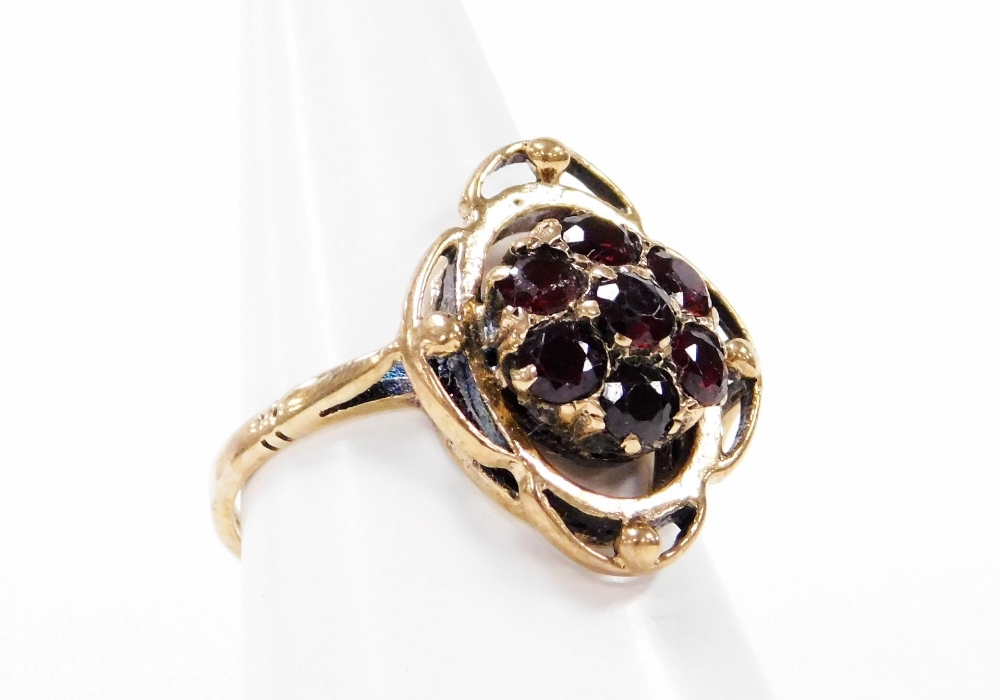 A 9ct gold garnet dress ring, the central cluster set with seven garnets, in Art Nouveau style, with